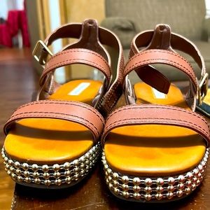 These are brown sandals with beads highlighting the shoe